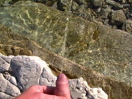 Pissing naked at beach.